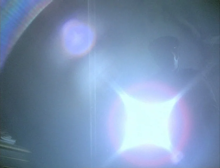 The Arrival of Joachim Stiller (1976) movie still: medium — An interior space is filled with heavy light haze and a bright flare. A silhouetted…
