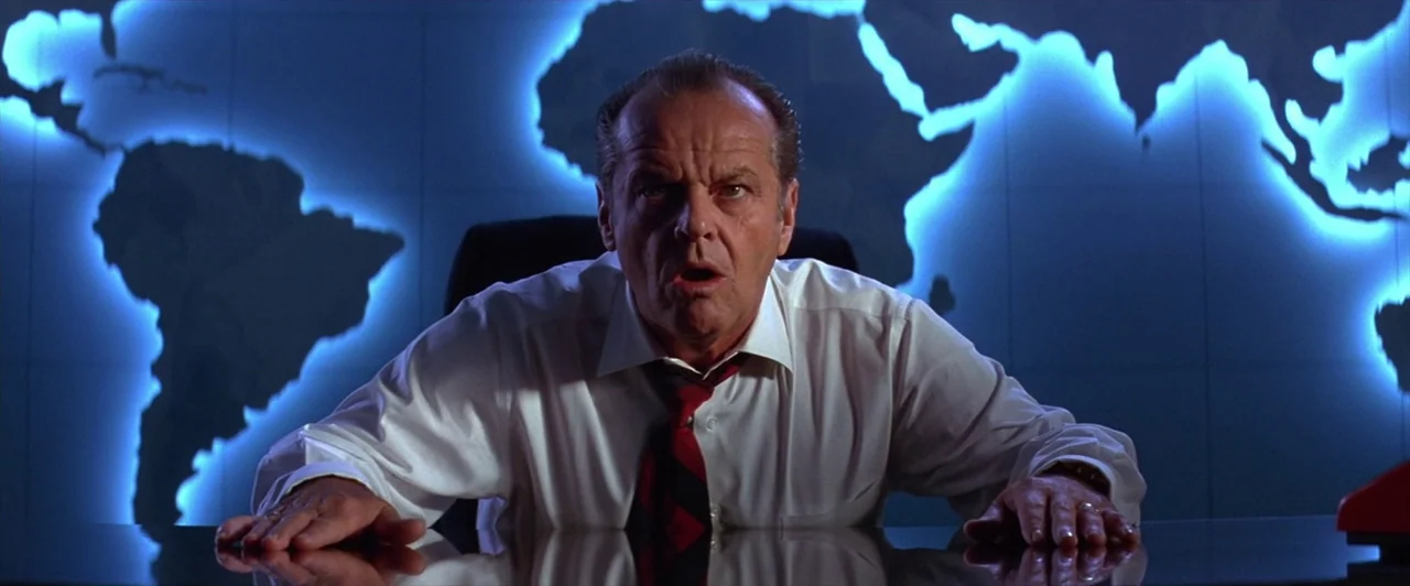Mars Attacks! (1996) movie still: medium — A modern command center features a large illuminated blue world map on the wall. A middle-aged man leans…