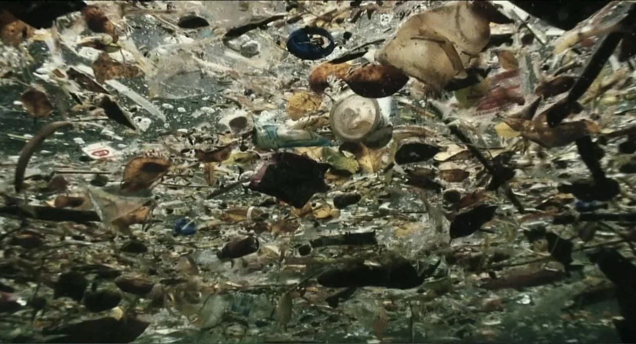 Pope Francis: A Man of His Word (2018) movie still: establishing — A dense layer of plastic trash and organic debris floats on the water surface.…