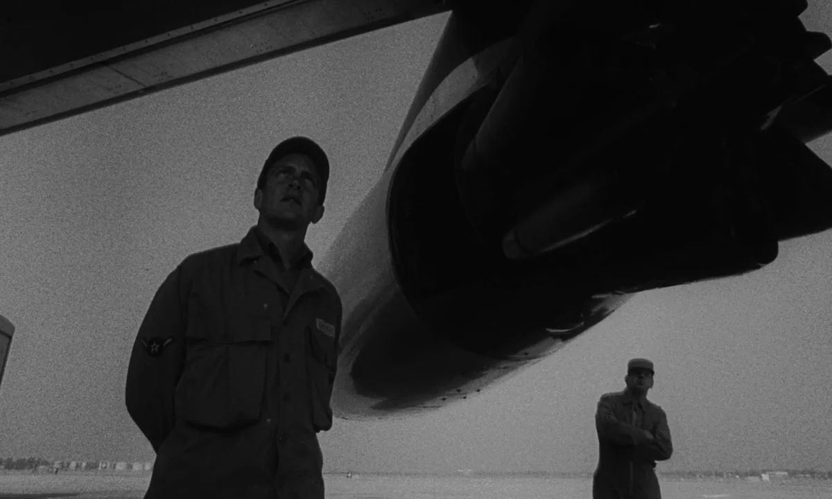 Dr. Strangelove or: How I Learned to Stop Worrying and Love the Bomb (1964) movie still: fullbody — A flat airfield sits under an overcast sky…