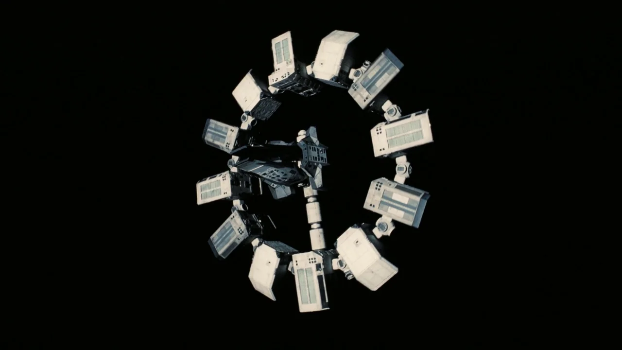 Interstellar (2014) movie still: wide — A rotating modular space station floats in the absolute darkness of deep space. The circular structure…