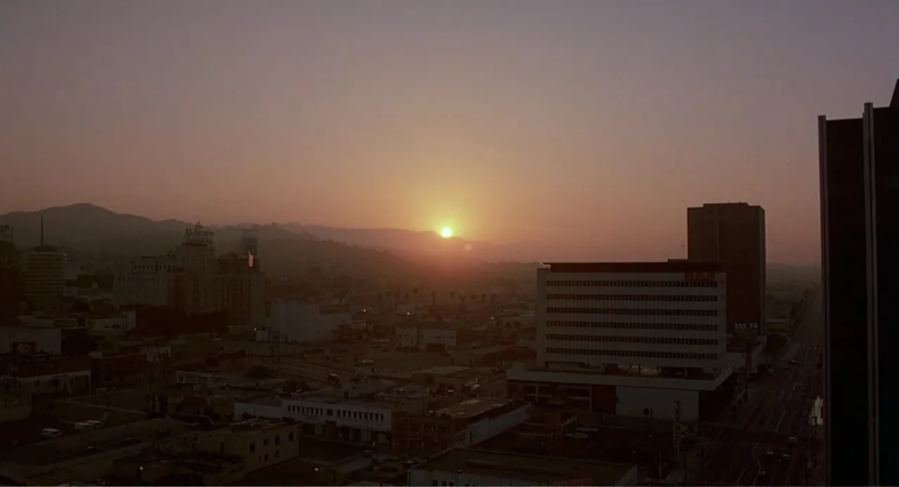 Death Wish II (1982) movie still: establishing — A panoramic urban cityscape viewed from an elevated position during sunset over the hills. Several…