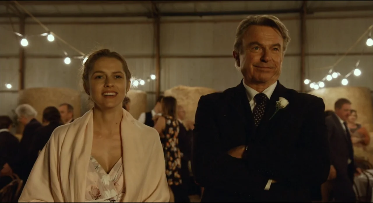 Ride Like a Girl (2019) movie still: medium — An event inside a large barn features guests mingling in the background near straw bales. A younger…