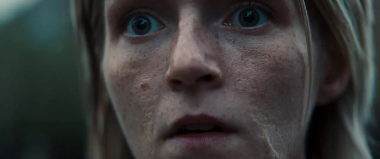 Silver Haze (2023) movie still: closeup — The frame shows a tight, detailed focus on a person's face. The subject stares directly forward with eyes…