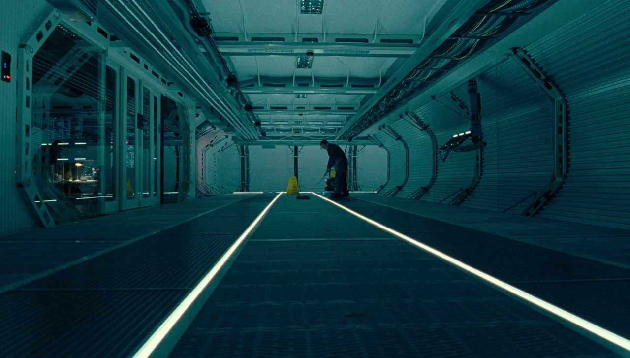 Justice League (2017) movie still: wide — A long, industrial spaceship corridor features reinforced metal walls and integrated floor-level lighting…