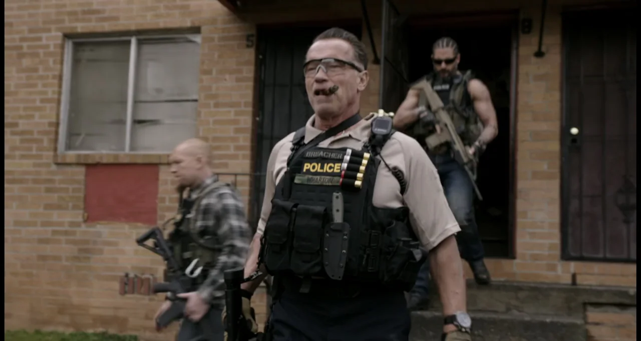 Sabotage (2014) movie still: medium — An exterior view of a brick apartment building with three men in tactical gear. The men move toward the camera…
