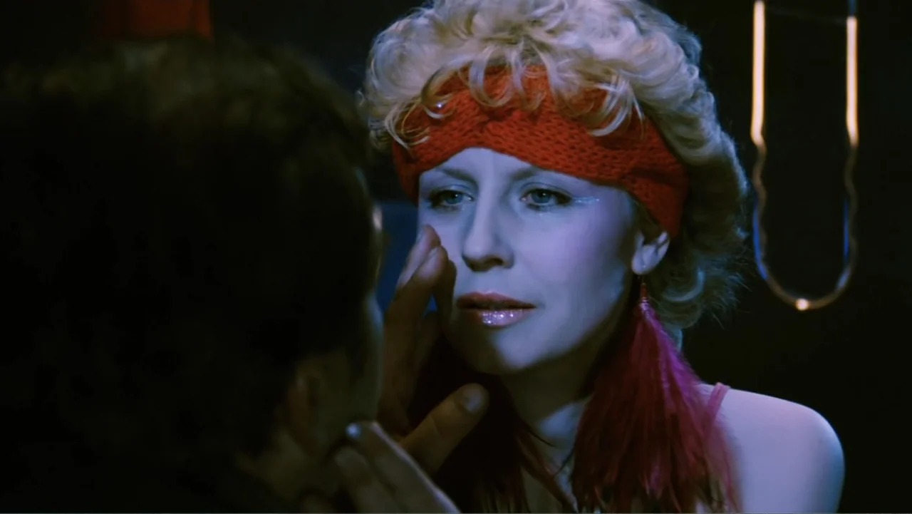 O-Bi, O-Ba: The End of Civilization (1985) movie still: closeup — A dark, dimly lit environment with glowing red neon tubes visible in the…
