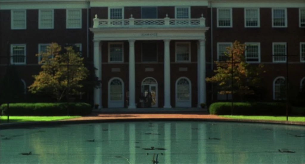 He Got Game (1998) movie still: establishing — A brick academic building with white columns stands behind a large circular reflective pool. Green…