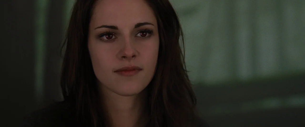 The Twilight Saga: Breaking Dawn – Part 2 (2012) movie still: closeup — A dimly lit, out-of-focus indoor space provides a neutral background for the…