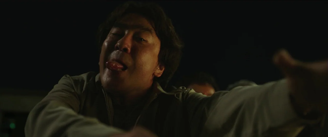 Psychokinesis (2018) movie still: closeup — A man makes a facial expression inside a darkened vehicle interior at night. The man leans forward…