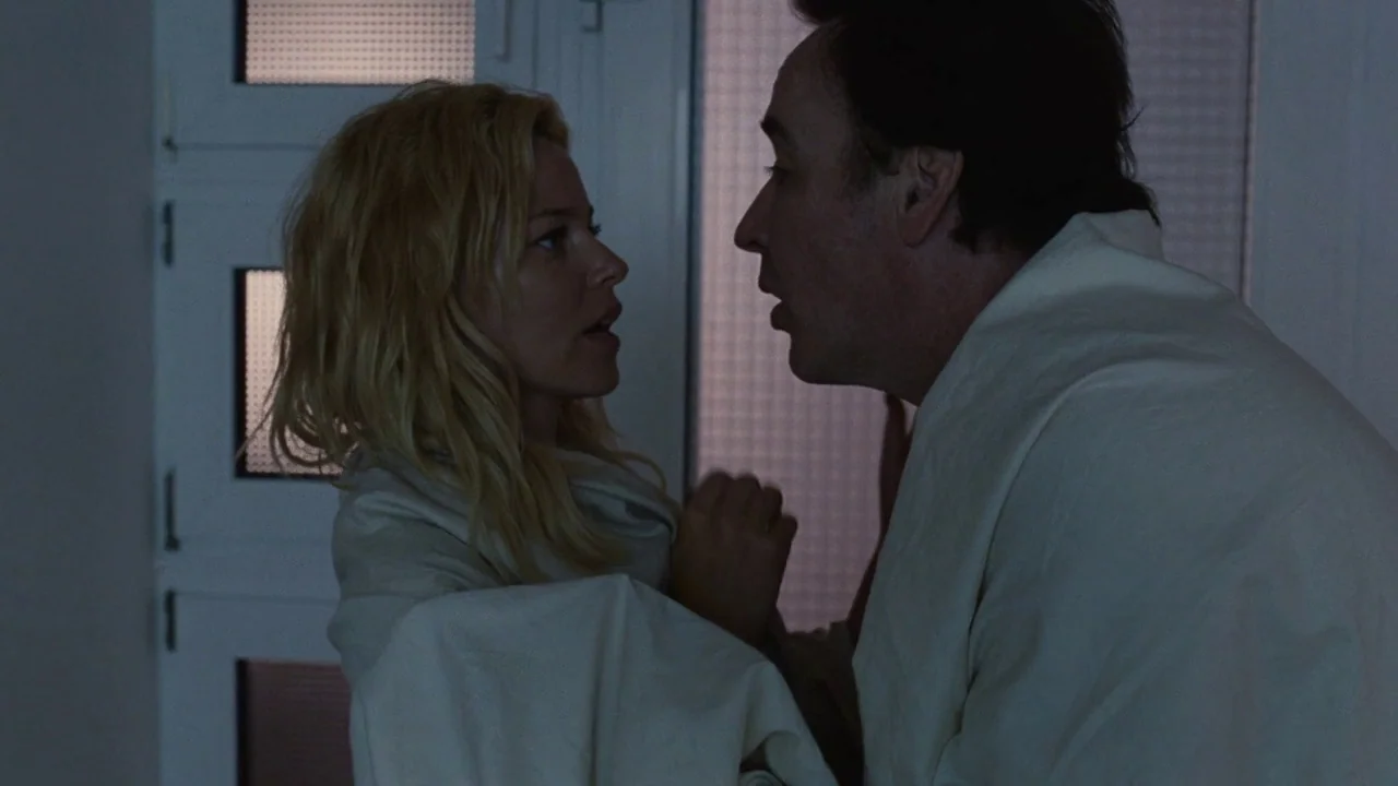 Love & Mercy (2014) movie still: medium — An interior space features textured glass doors in the background under dim ambient light. A man and a…