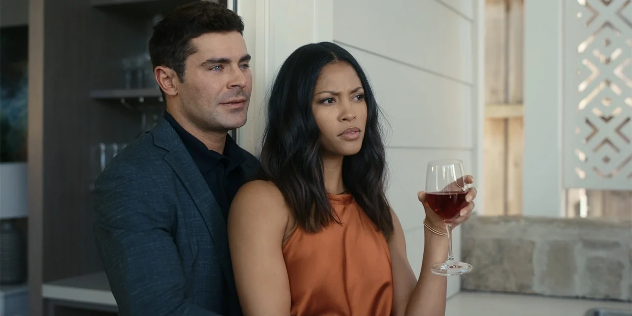 Ricky Stanicky (2024) movie still: medium — A modern home interior features light walls and subtle architectural details in the background. A man…