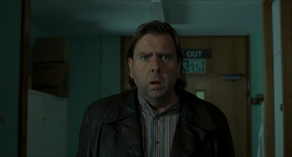 All or Nothing (2002) movie still: medium — An institutional hospital corridor features light green walls and a wooden exit door. A middle-aged man…