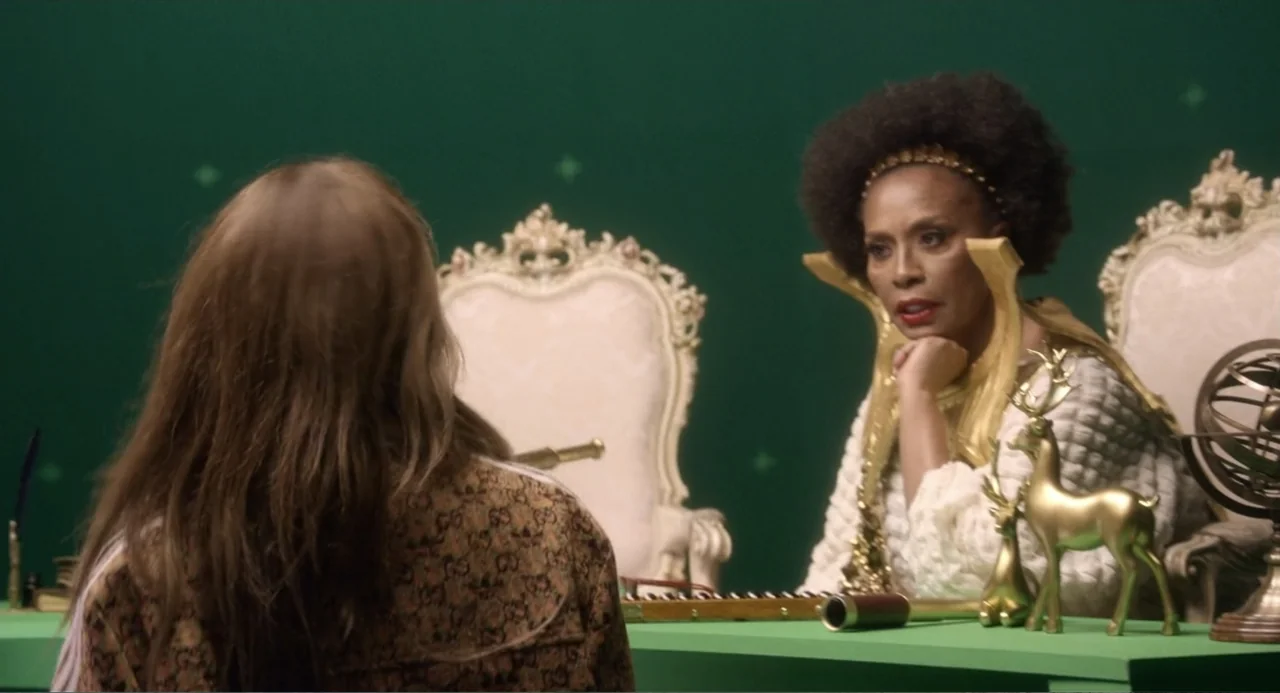 The Greatest Love Story Never Told (2024) movie still: medium — An ornate throne sits in front of a digital green screen background. A woman in…