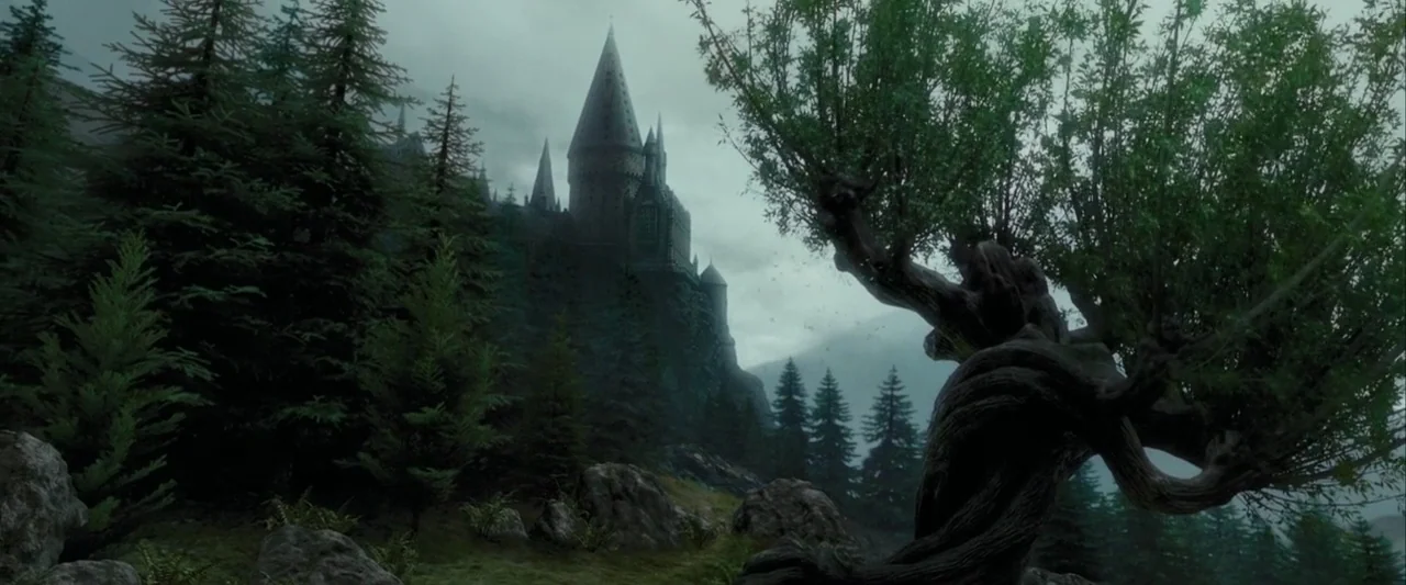 Harry Potter and the Prisoner of Azkaban (2004) movie still: establishing — A stone castle with multiple spires stands atop a rocky cliff in the…