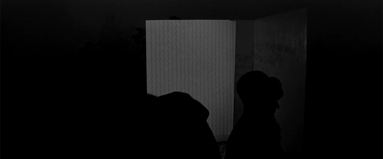 Jules and Jim (1962) movie still: medium — A dark interior room features a starkly illuminated rectangular doorway against deep surrounding shadow.…