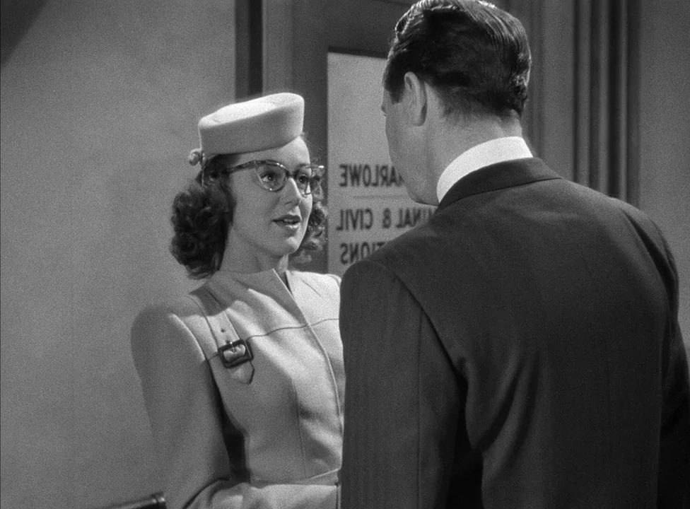Murder, My Sweet (1944) movie still: medium — An interior space with a frosted glass door displaying backwards lettering of a name. A woman wearing…