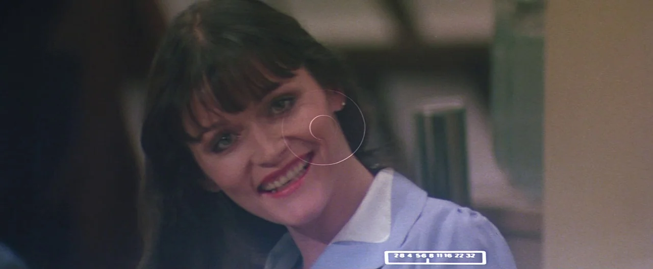 Superman (1978) movie still: closeup — A woman in a blue uniform is positioned within an indoor space. She looks toward the camera with a wide smile.