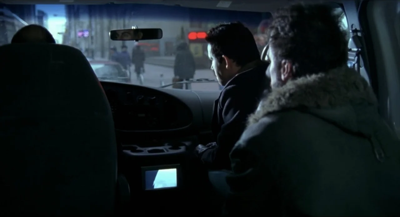 Foolproof (2003) movie still: medium — The interior of a parked van with a view through the front windshield. Two men sit in the front seats…