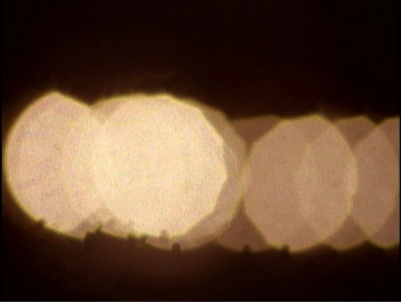 America Undercover: Life Afterlife (2000) movie still: closeup — A dark space contains multiple out-of-focus circular light sources overlapping each…