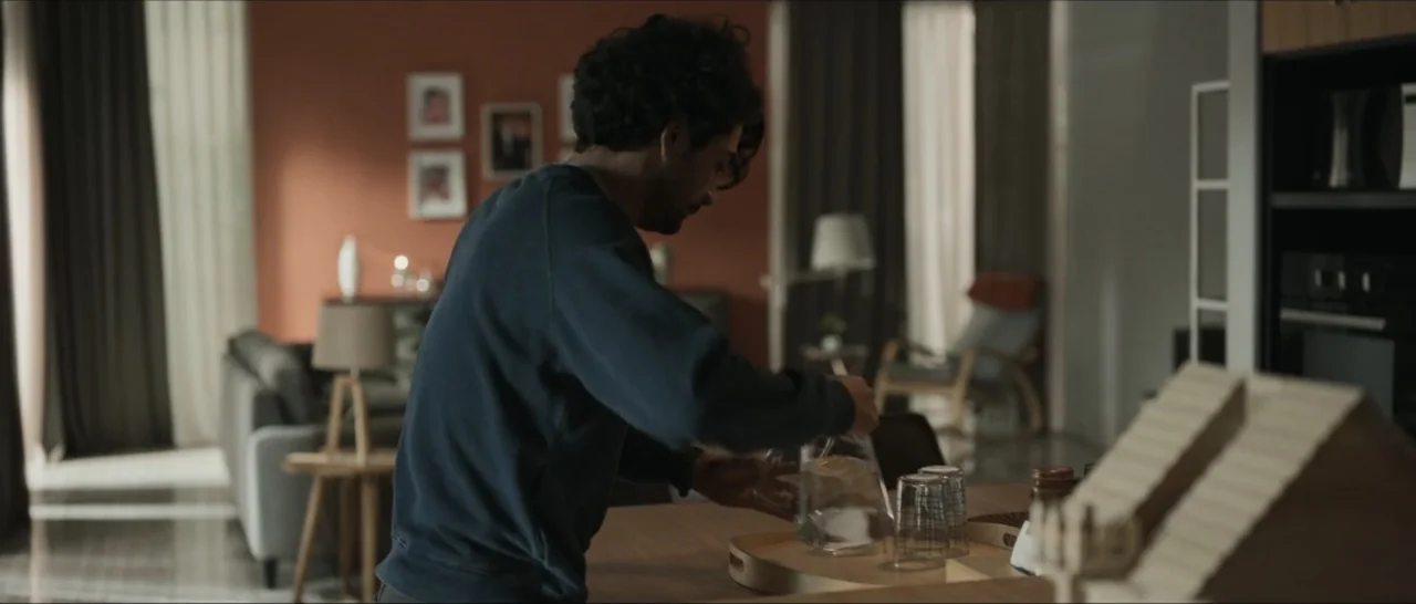 Innocent Vengeance (2023) movie still: medium — A contemporary dining room features terracotta walls, minimalist furniture, and framed artwork on…