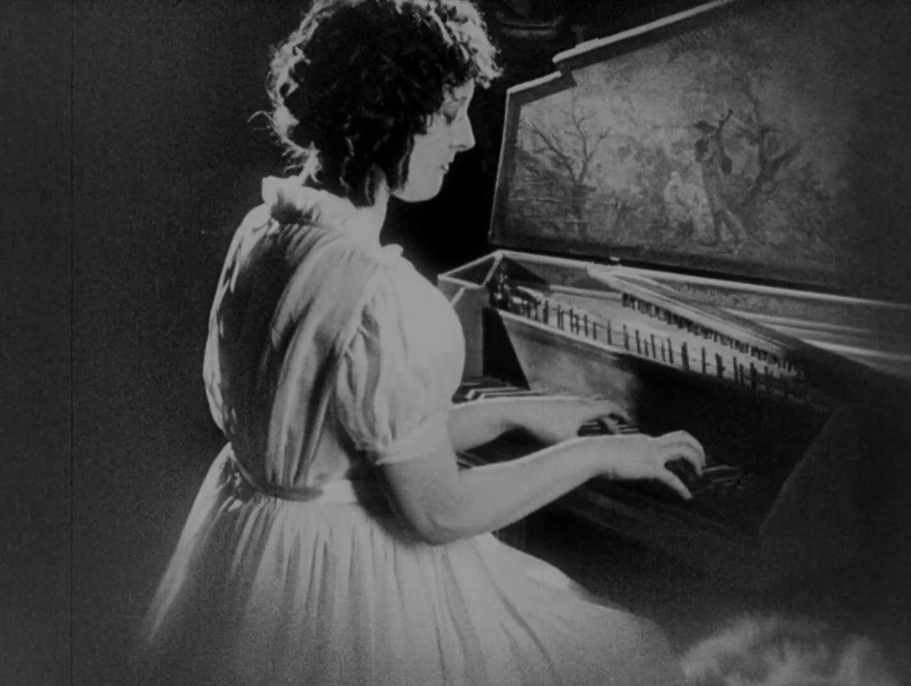 Napoleon (1927) movie still: medium — A woman sits at an ornate harpsichord in a dimly lit, dark space. The instrument features a decorative…