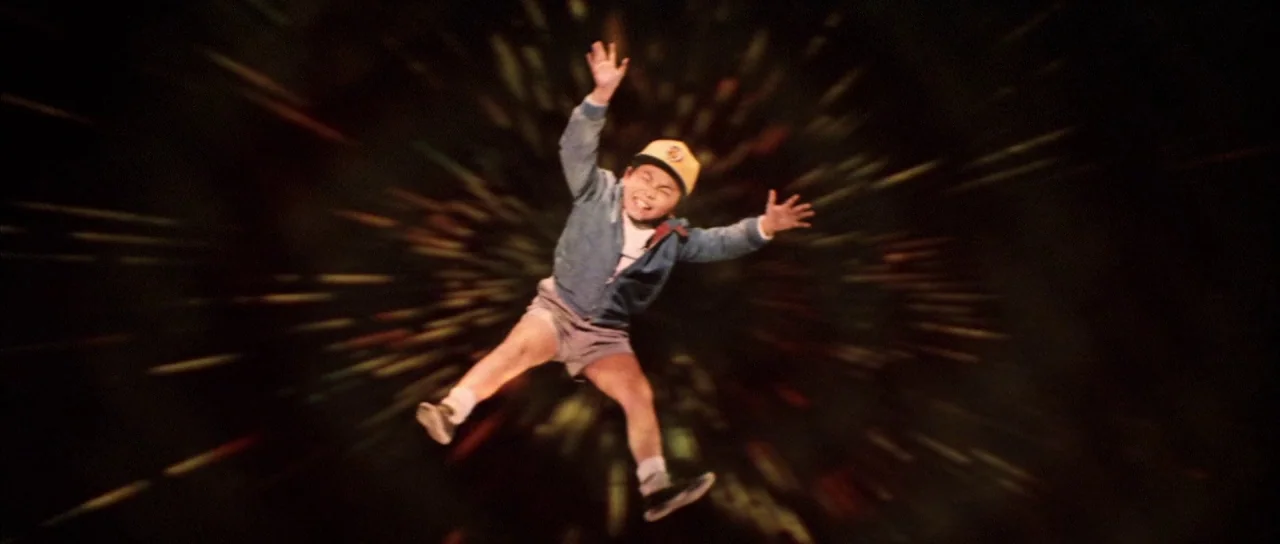 All Monsters Attack (1969) movie still: fullbody — An abstract, dark void surrounds a floating figure with motion-blurred light streaks radiating…