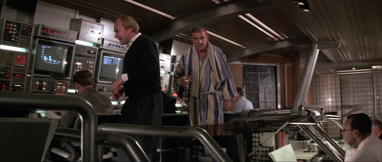 Never Say Never Again (1983) movie still: medium — A high-tech 1980s computer control room is filled with consoles and glowing monitors. A man in a…