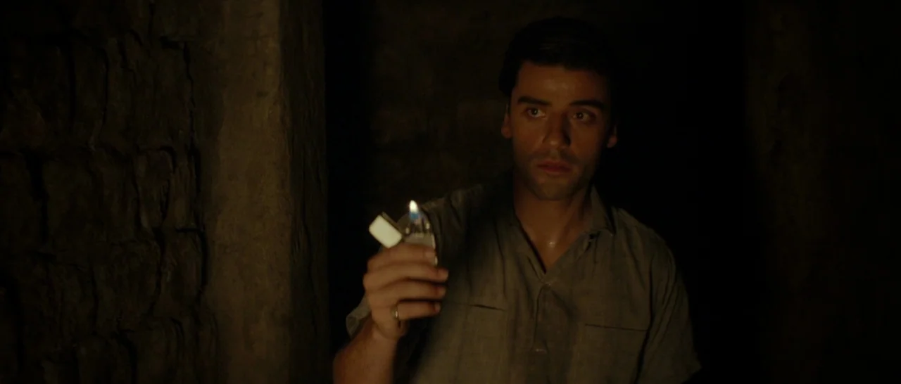 The Two Faces of January (2014) movie still: medium — A dark stone passageway with textured, uneven walls and deep, impenetrable shadows. A man…