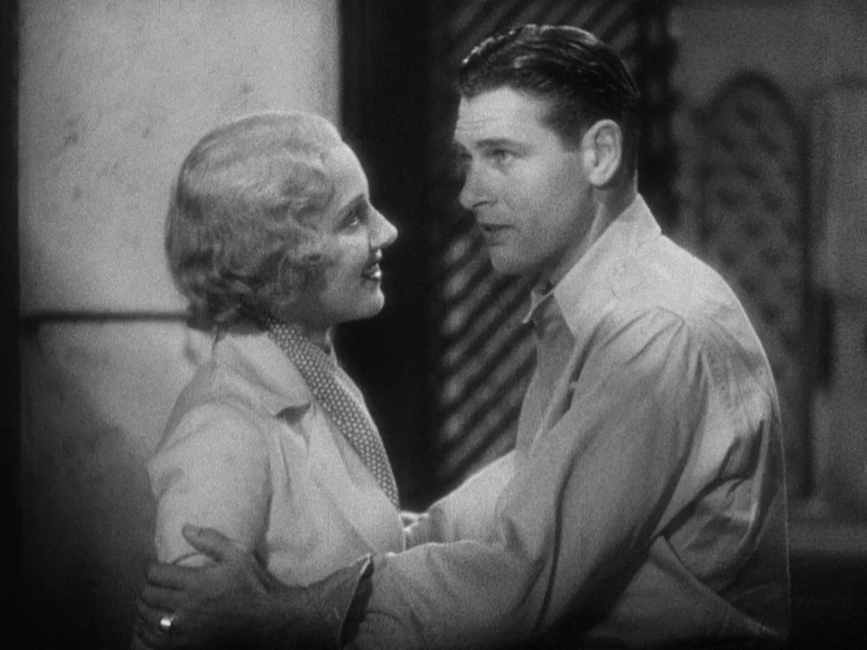 Island of Lost Souls (1932) movie still: medium — An interior space with a partially visible slatted partition in the background. A man holds a…