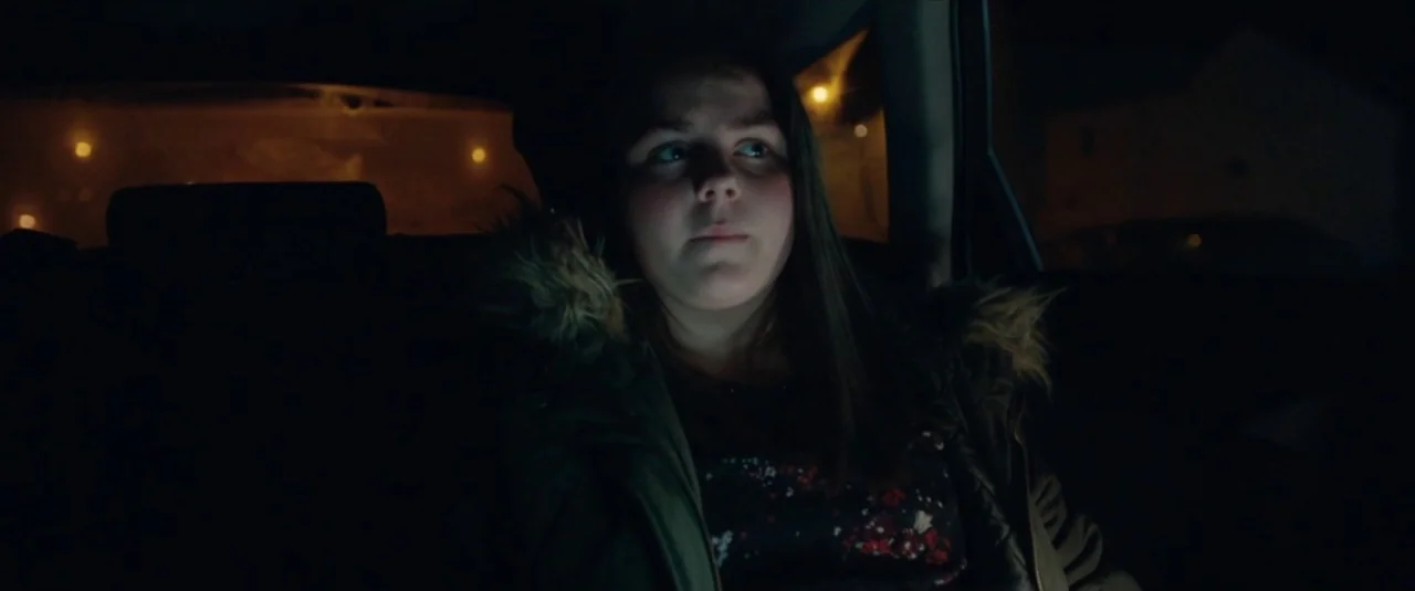 Happy New Year, Colin Burstead (2018) movie still: medium — The interior of a car at night with dark surroundings and glowing city lights outside. A…
