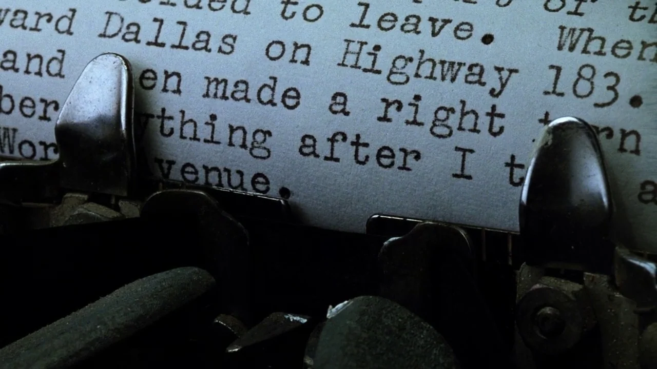 The Thin Blue Line (1988) movie still: closeup — A close-up view shows a sheet of paper fed into a metal typewriter carriage. Dark, crisp ink…