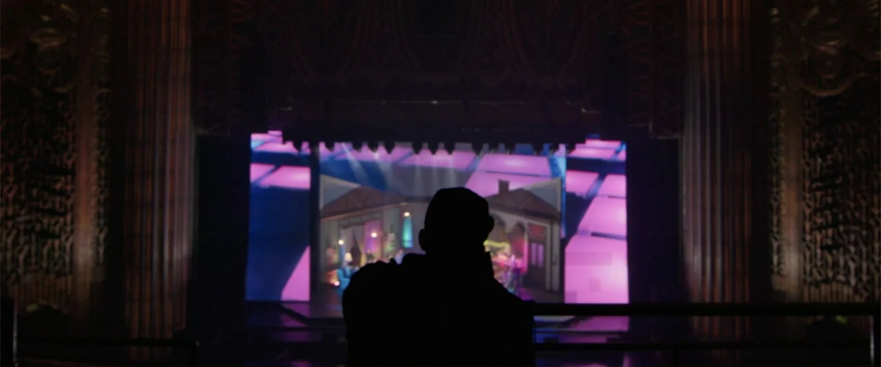 Maxine's Baby: The Tyler Perry Story (2023) movie still: medium — An ornate interior theater balcony with shadowed walls and columns surrounding the…