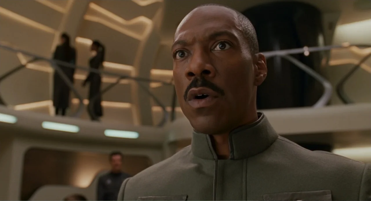 Meet Dave (2008) movie still: medium — A futuristic command deck with curved walls and recessed LED light strips. A middle-aged man in a military…