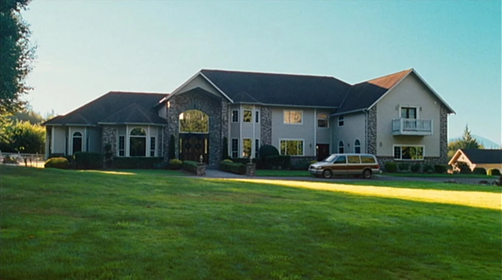 Visioneers (2008) movie still: establishing — A large two-story suburban house sits in the middle of a spacious lawn. A van is parked on the…