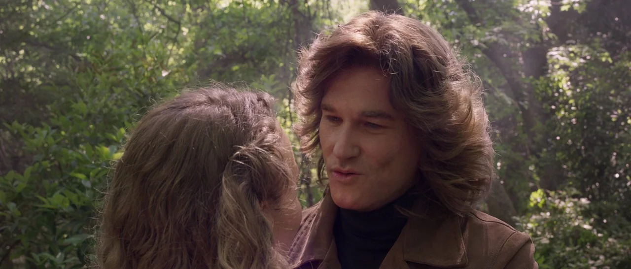 Guardians of the Galaxy Vol. 2 (2017) movie still: medium — Two individuals interact amidst the dense foliage of a sunlit woodland environment. The…