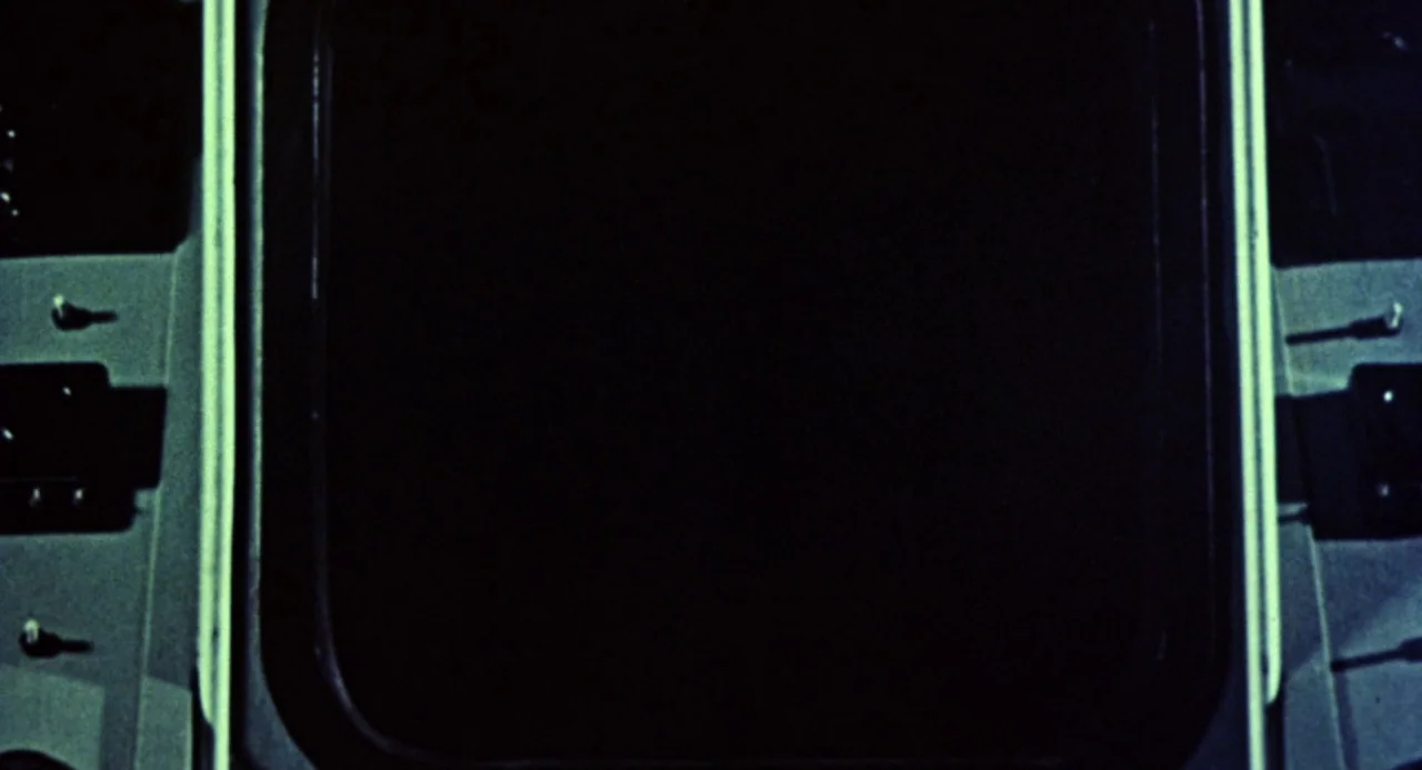Queen of Blood (1966) movie still: closeup — A close-up view of a dark, rectangular screen set within a metallic control panel. Rows of small,…