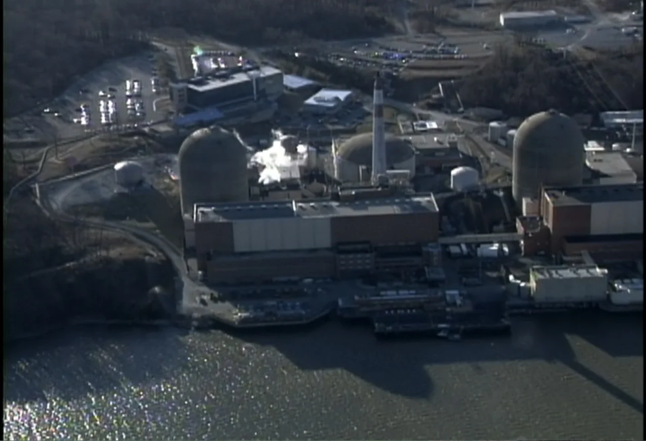 Indian Point: Imagining the Unimaginable (2004) movie still: establishing — An aerial view displays a large nuclear power plant complex next to a…