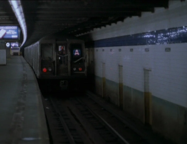 The Brother From Another Planet (1984) movie still: wide — A dark underground transit station features tiled walls and a long concrete platform. An…