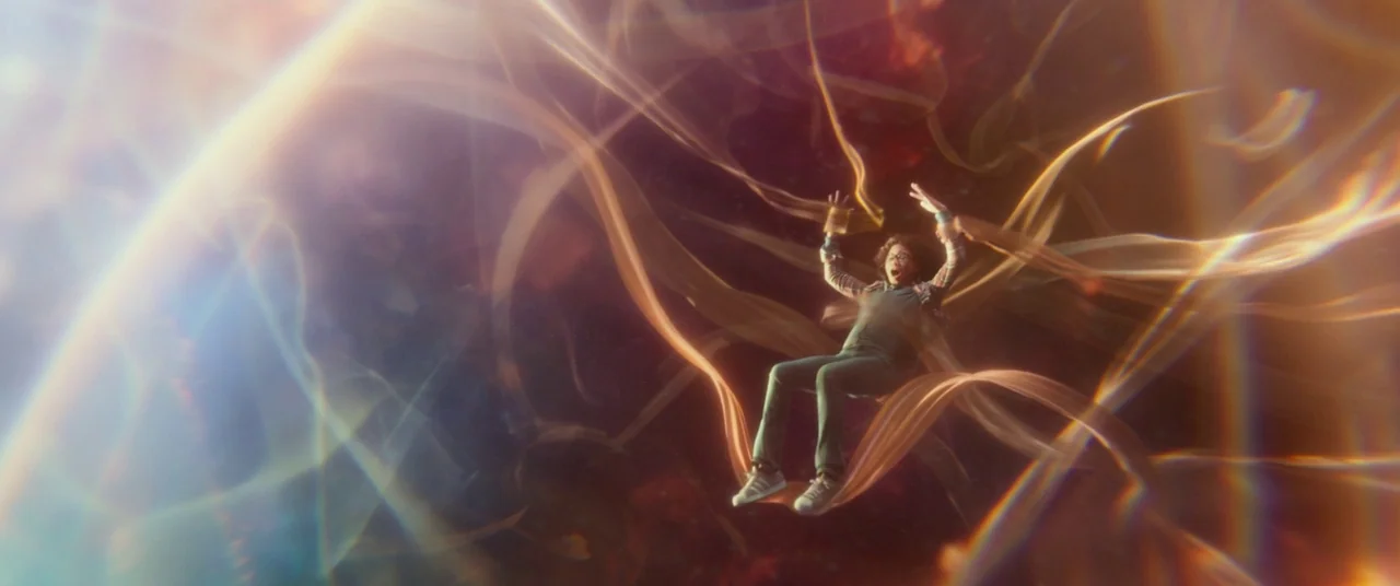 A Wrinkle In Time (2018) movie still: wide — A teenage boy floats in a dark void filled with twisting ribbons of golden light. He reaches his arms…