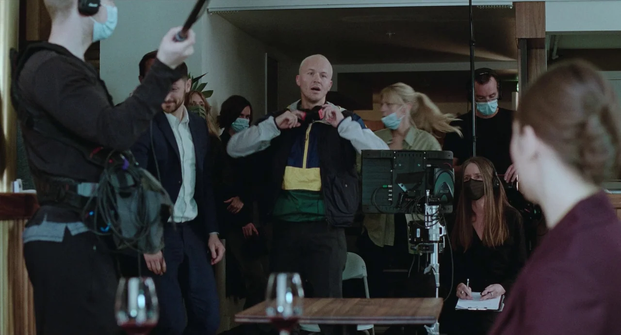 The Worst Person in the World (2021) movie still: medium — A film production set interior features various crew members gathered around a camera…