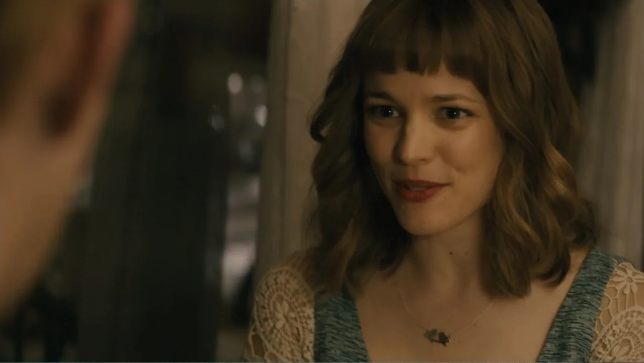 About Time (2013) movie still: medium — A well-lit indoor living space with soft focus background elements. A woman sits and speaks to someone…