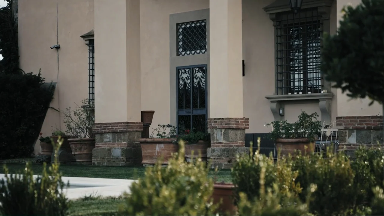 Federico Chiesa - Back on Track (2023) movie still: establishing — A stone villa facade features large pillars, iron-grated windows, and terracotta…