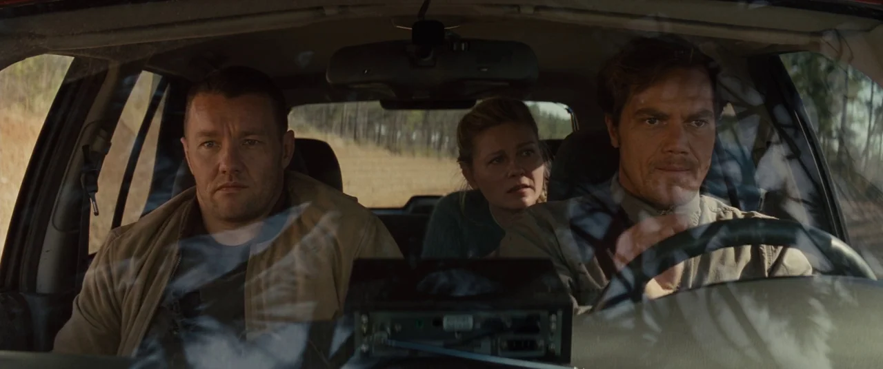 Midnight Special (2016) movie still: medium — Three people sit together inside a car driving through a rural, sun-drenched landscape. They are all…