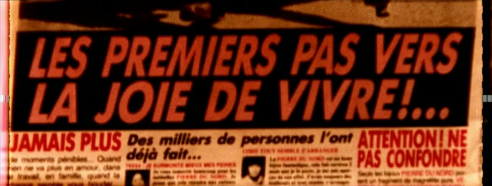 Carne (1991) movie still: closeup — A close-up of a printed newspaper page with bold French headlines in red. Text columns flank the central…