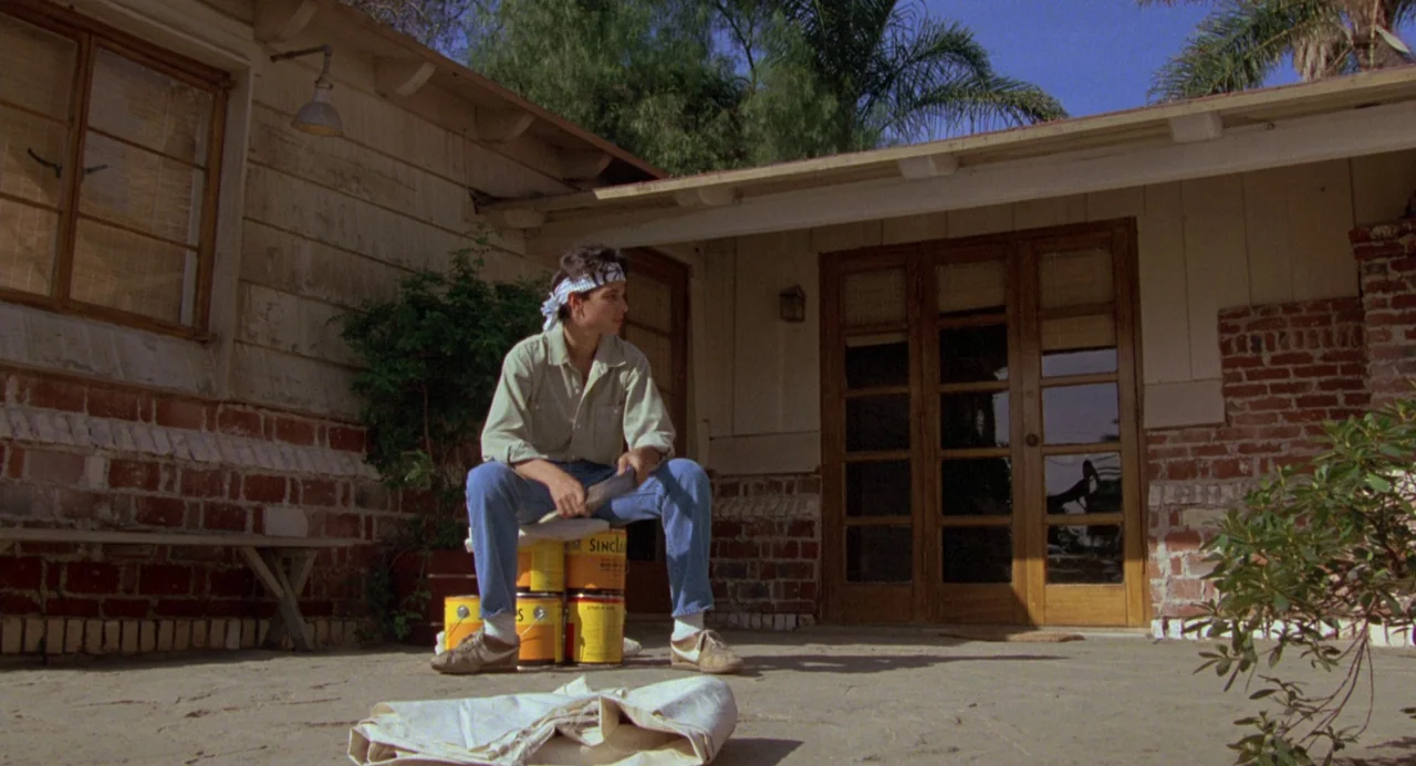 The Karate Kid (1984) movie still: fullbody — A single-story residence features exterior brick and wooden siding with a paved patio. A teenager…