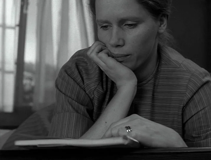 Hour of the Wolf (1968) movie still: closeup — An interior space features a woman sitting near a translucent window curtain. She rests her chin on…