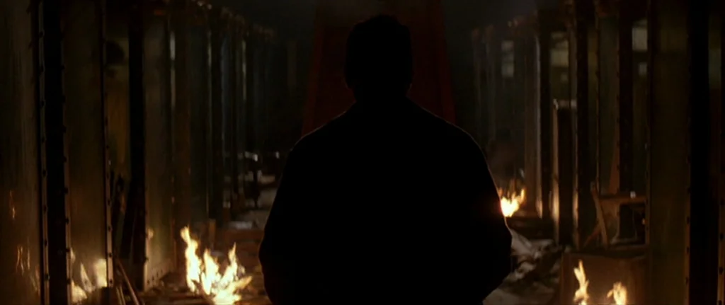 The Prestige (2006) movie still: medium — An industrial space features rows of large metal enclosures lining a central corridor. A silhouetted…