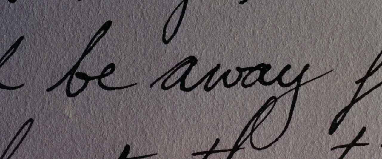 The Age of Innocence (1993) movie still: closeup — Textured off-white paper features lines of cursive handwriting written in dark ink. The close…