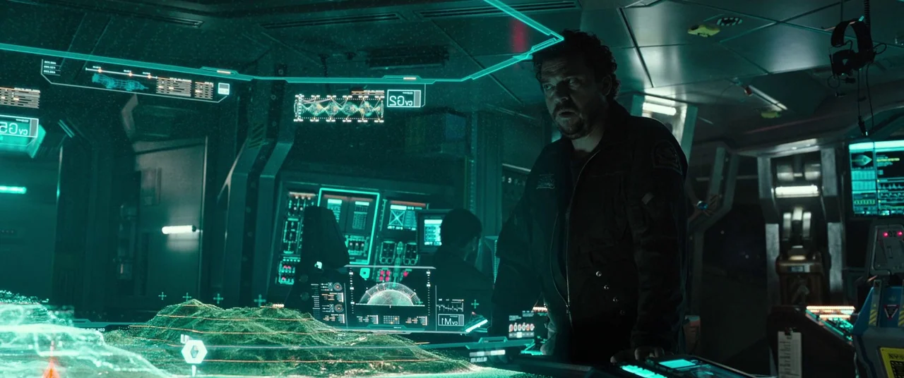 Alien: Covenant (2017) movie still: medium — The interior of a spaceship bridge features metallic walls and numerous glowing green interface panels.…